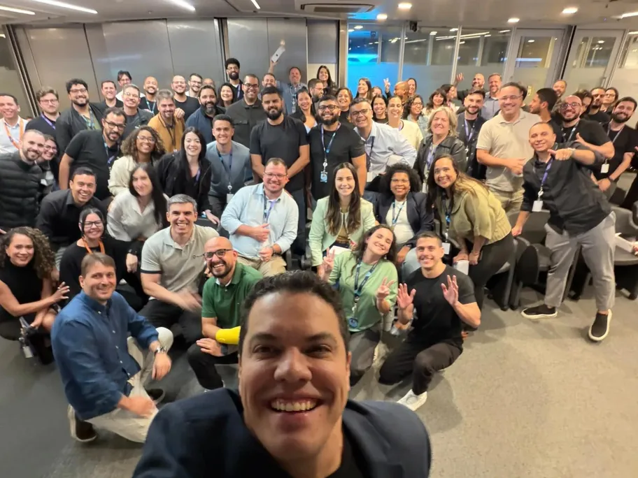 Foto em grupo com o time comercial da TOTVS sorrindo em uma sala de treinamento