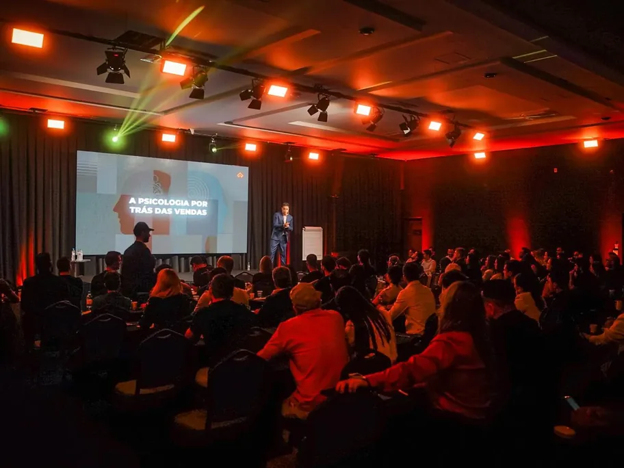 Palestra em evento da Vivo com plateia lotada e telão exibindo o slide A psicologia por trás das vendas